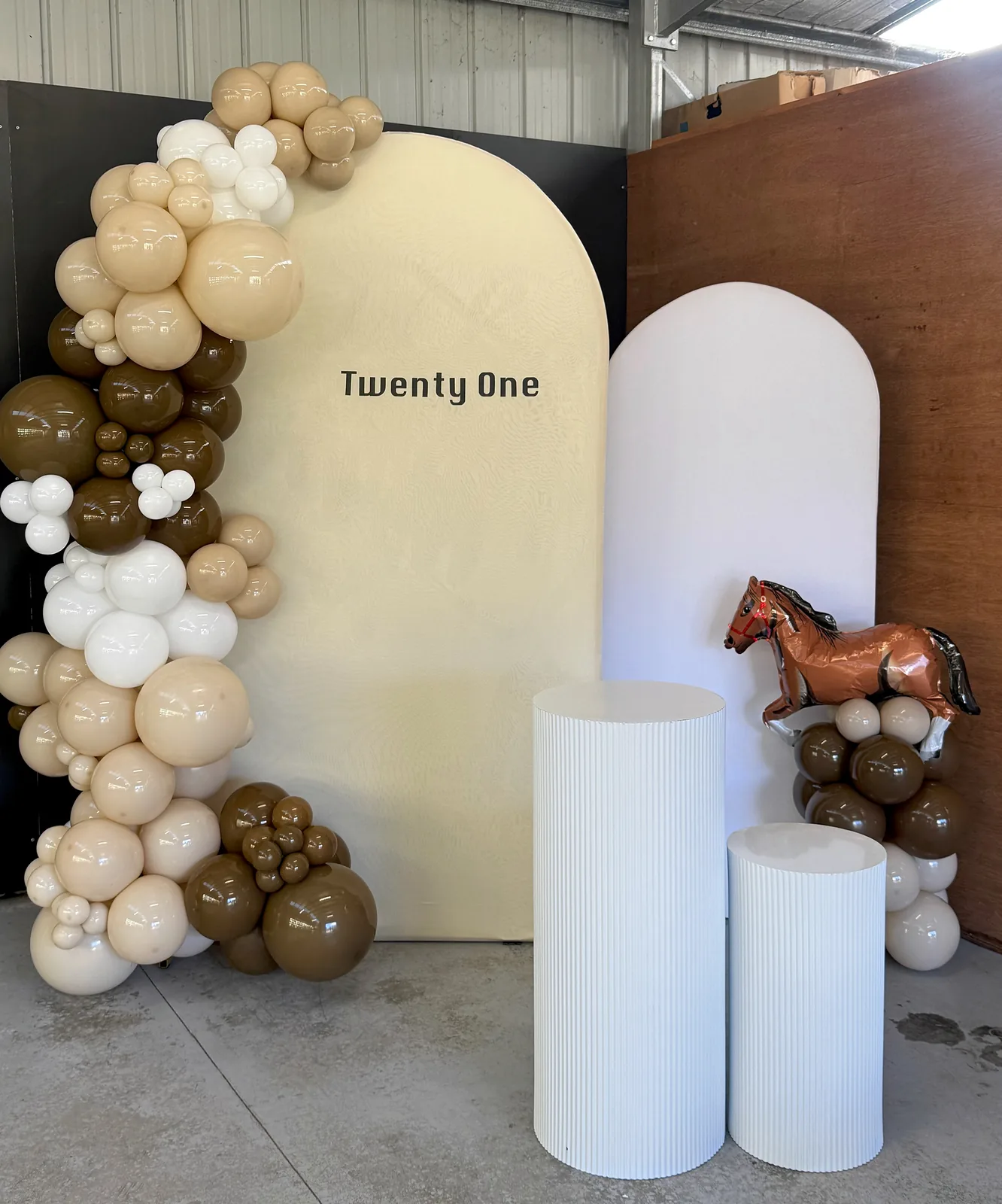 Neutral 21st birthday display in Diamond Creek with cream and brown balloons, Twenty One backdrop, white plinths and a horse balloon.